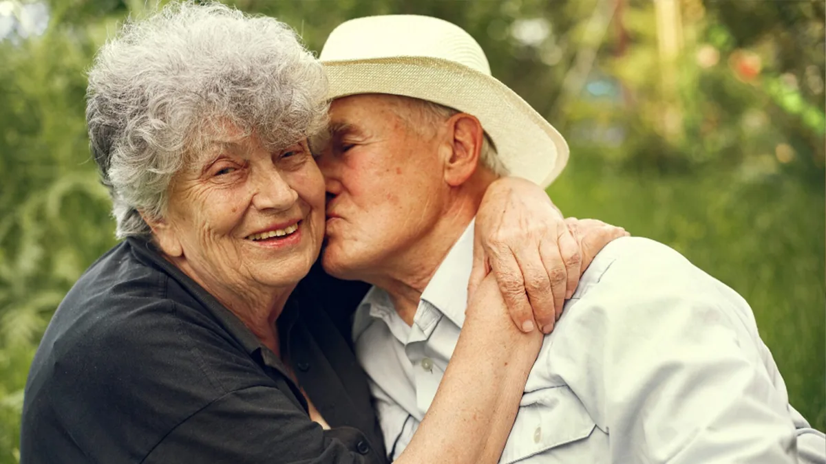 A caregiver sitting with an older woman in her living room